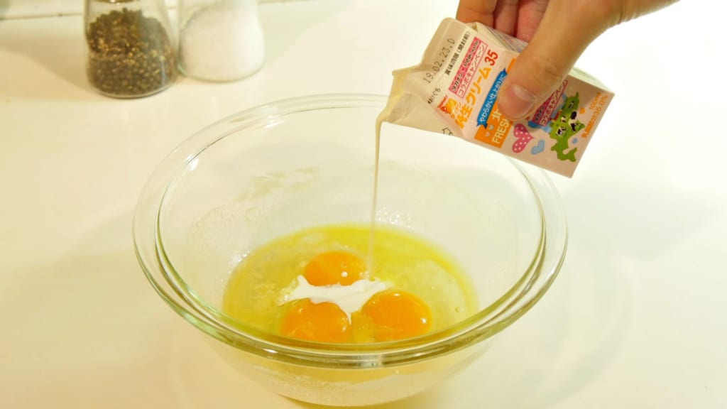 卵に生クリームを入れている